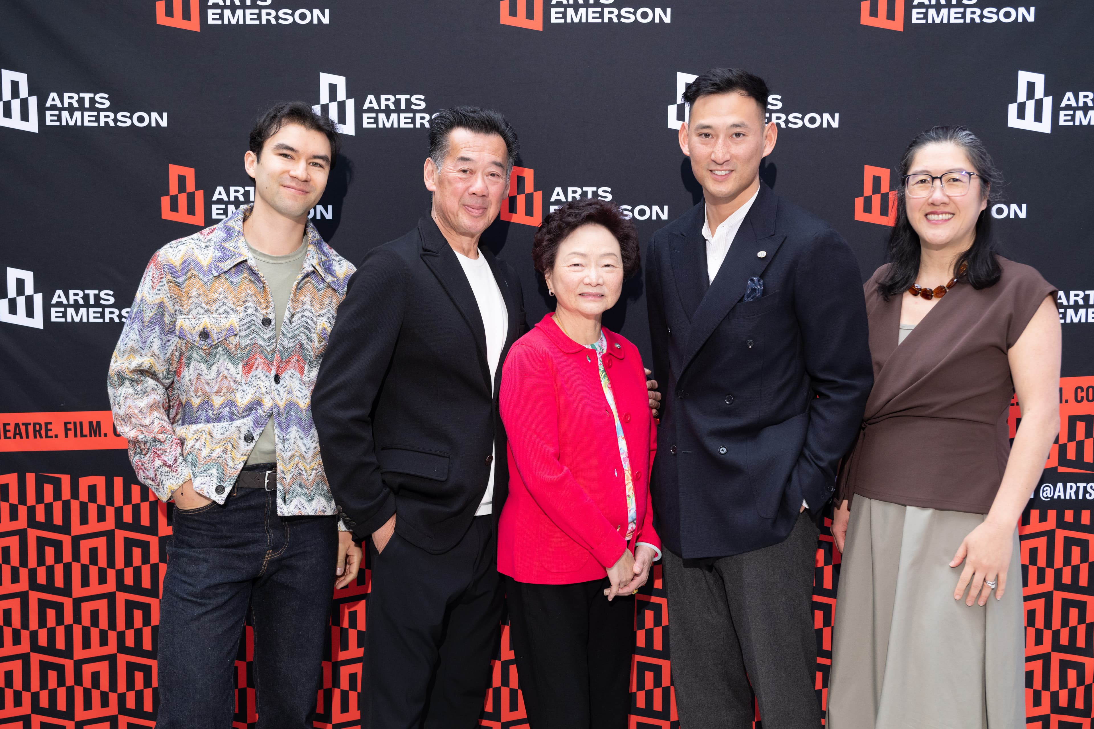 Five people posing together in front of an Arts Emerson step-and-repeat backdrop, dressed for an evening screening event.