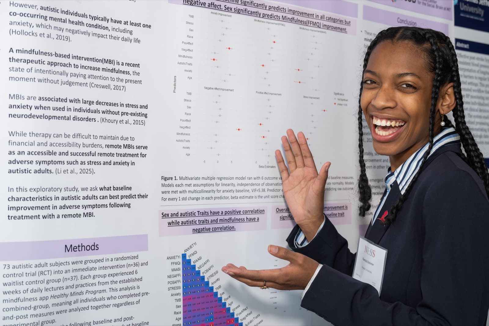 Woman with braided hair gesturing at a research poster filled with text and data charts.