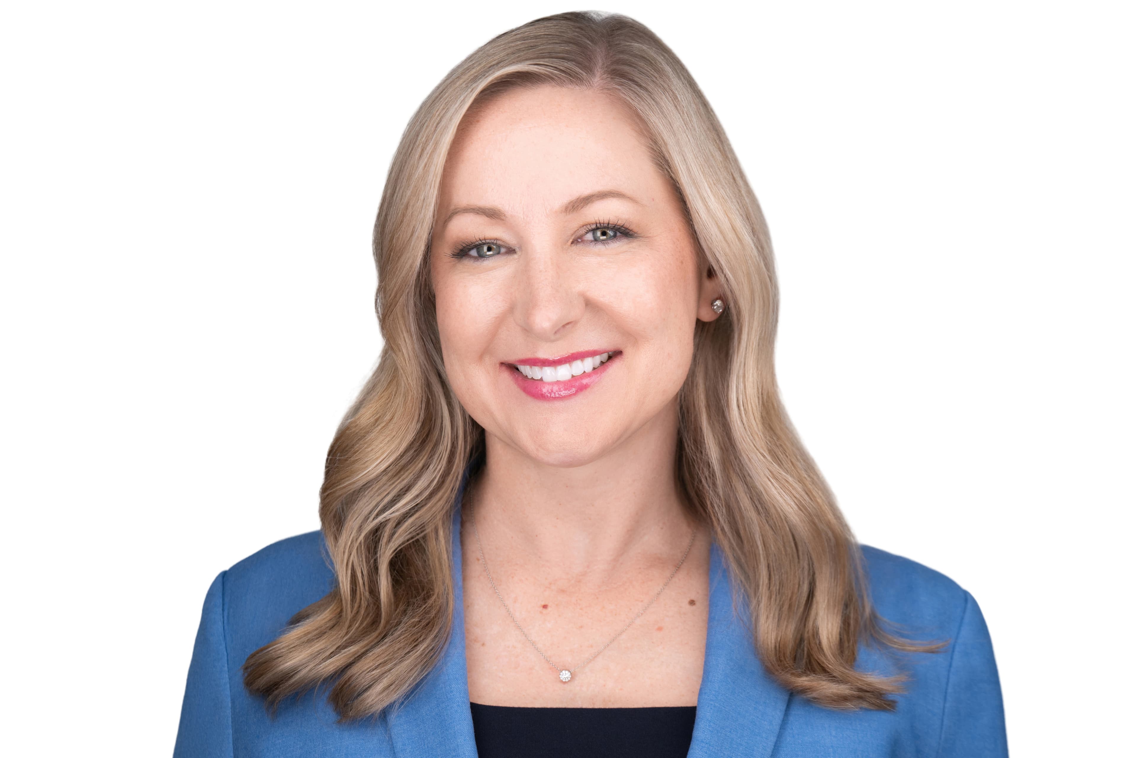 Woman with a bright smile in a blue blazer, a close studio headshot crop against a white background.