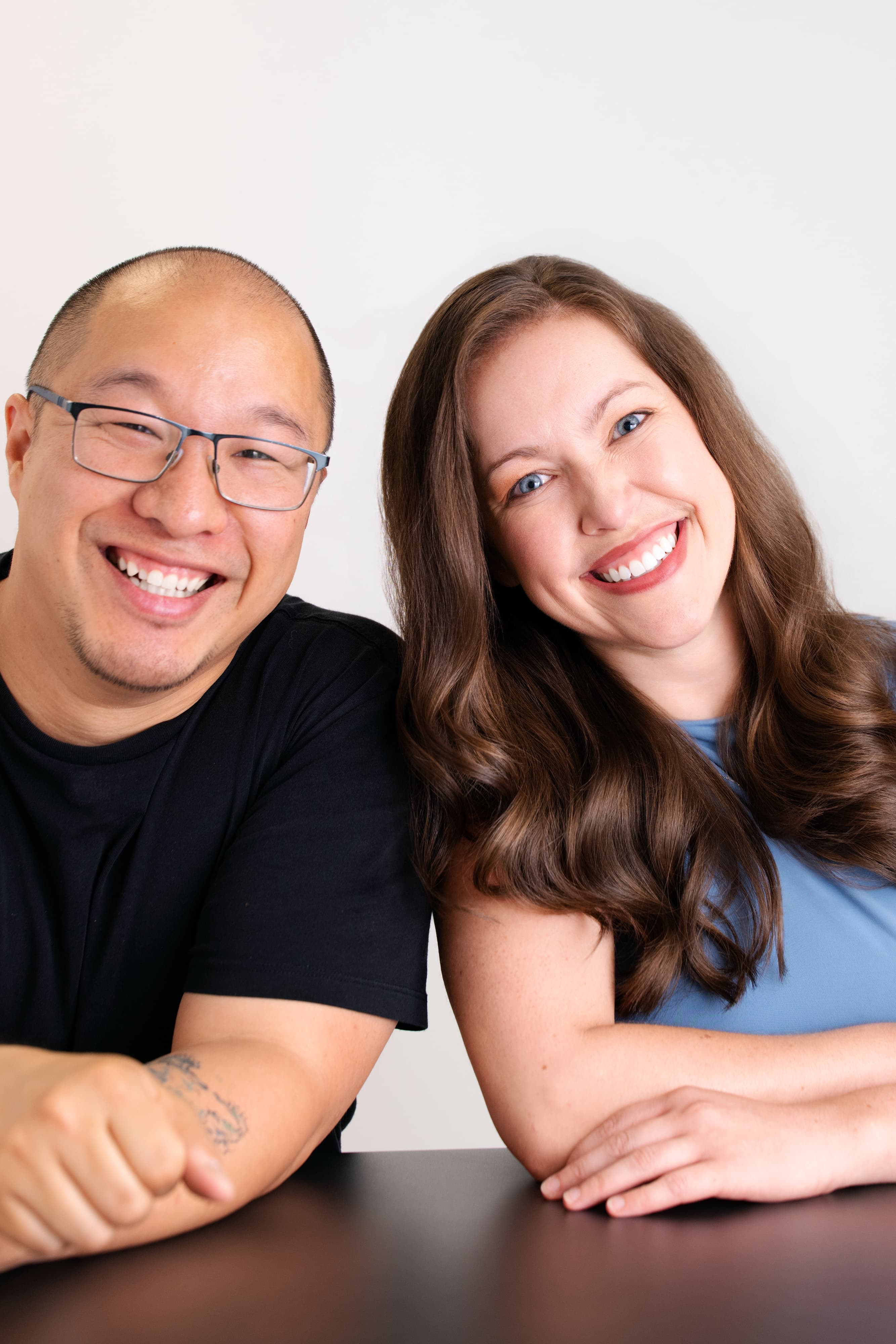 Man and woman smiling closely together in a studio portrait.