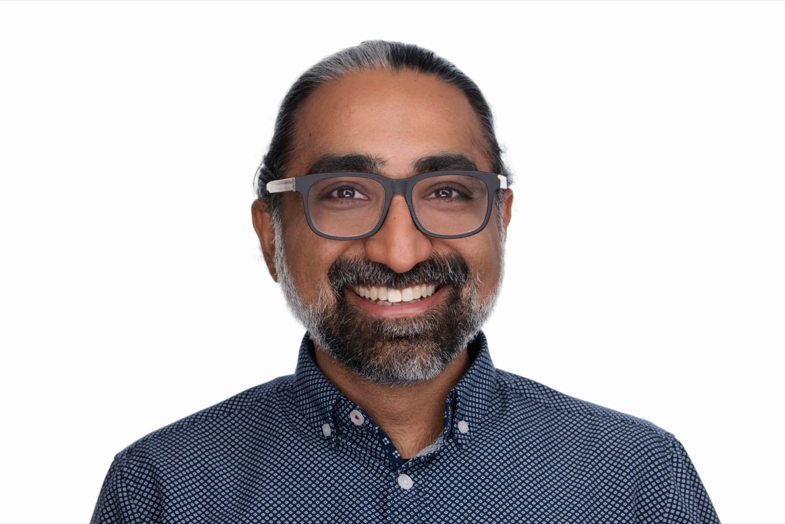 Set of individual booth headshots against a dark background, one wearing an event pin.